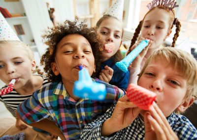 Kids blowing party blowers at a children's disco party